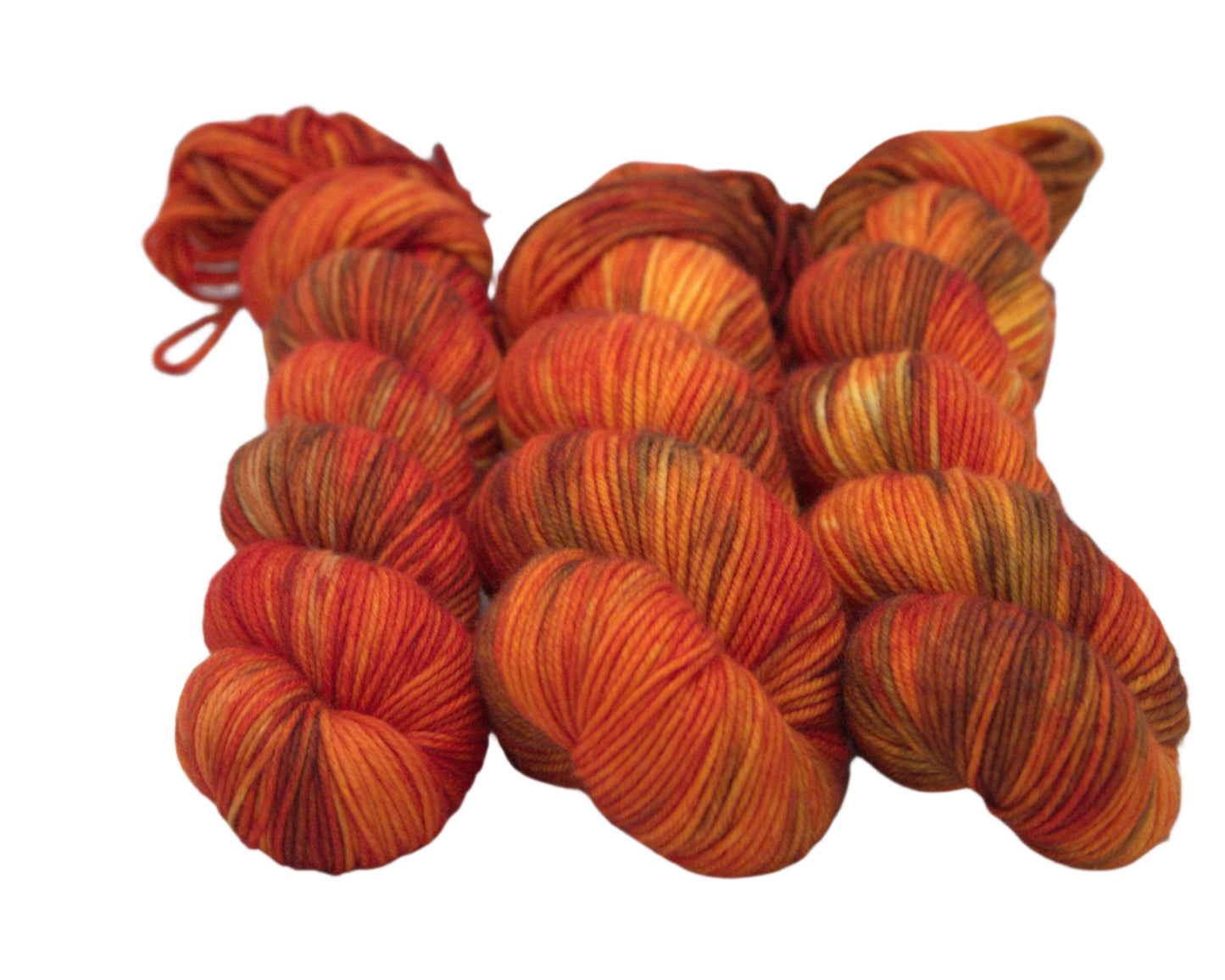 three twisted skeins variegated orange and brown yarn on white background.