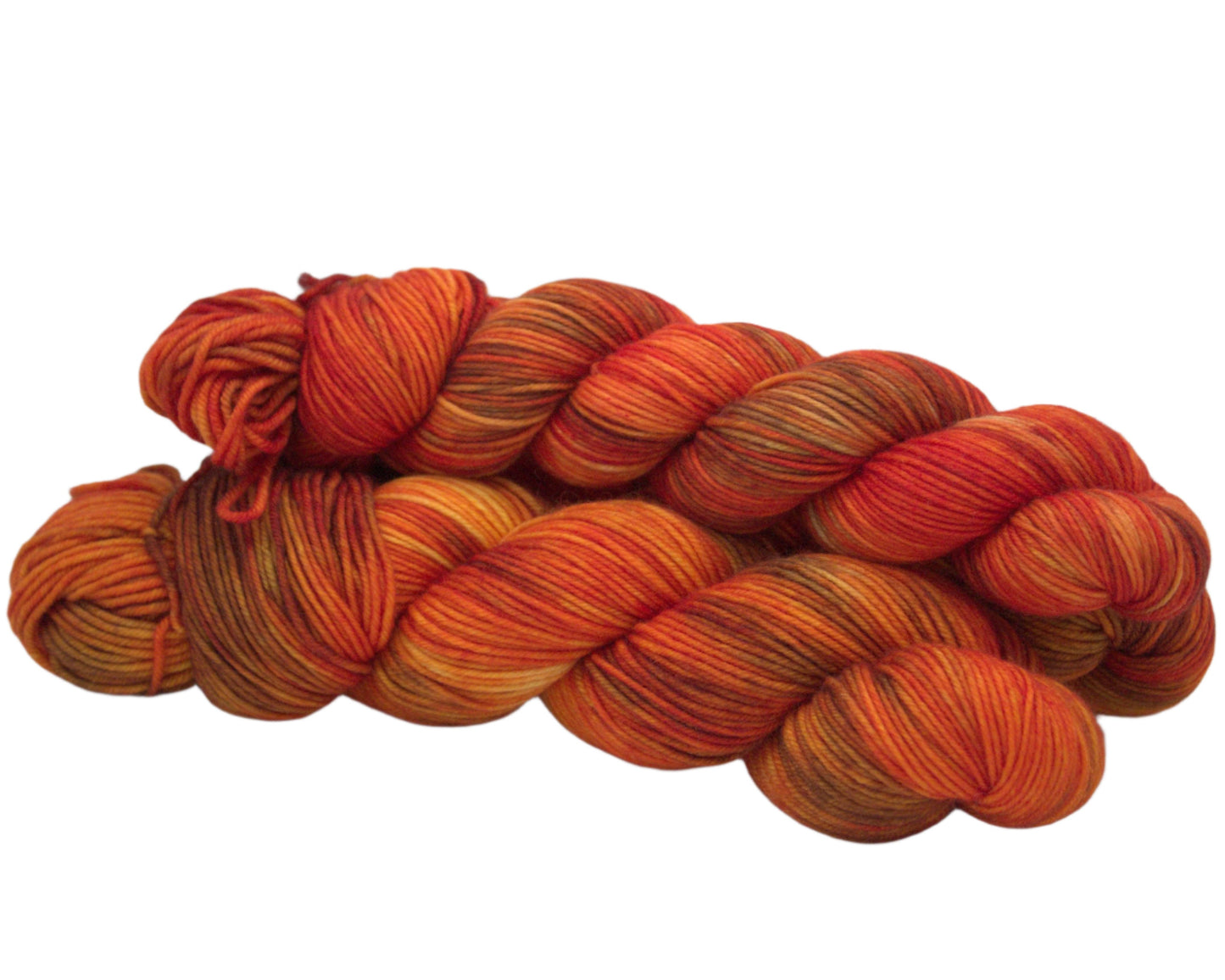 side view of three twisted skeins variegated orange and brown yarn on white background.