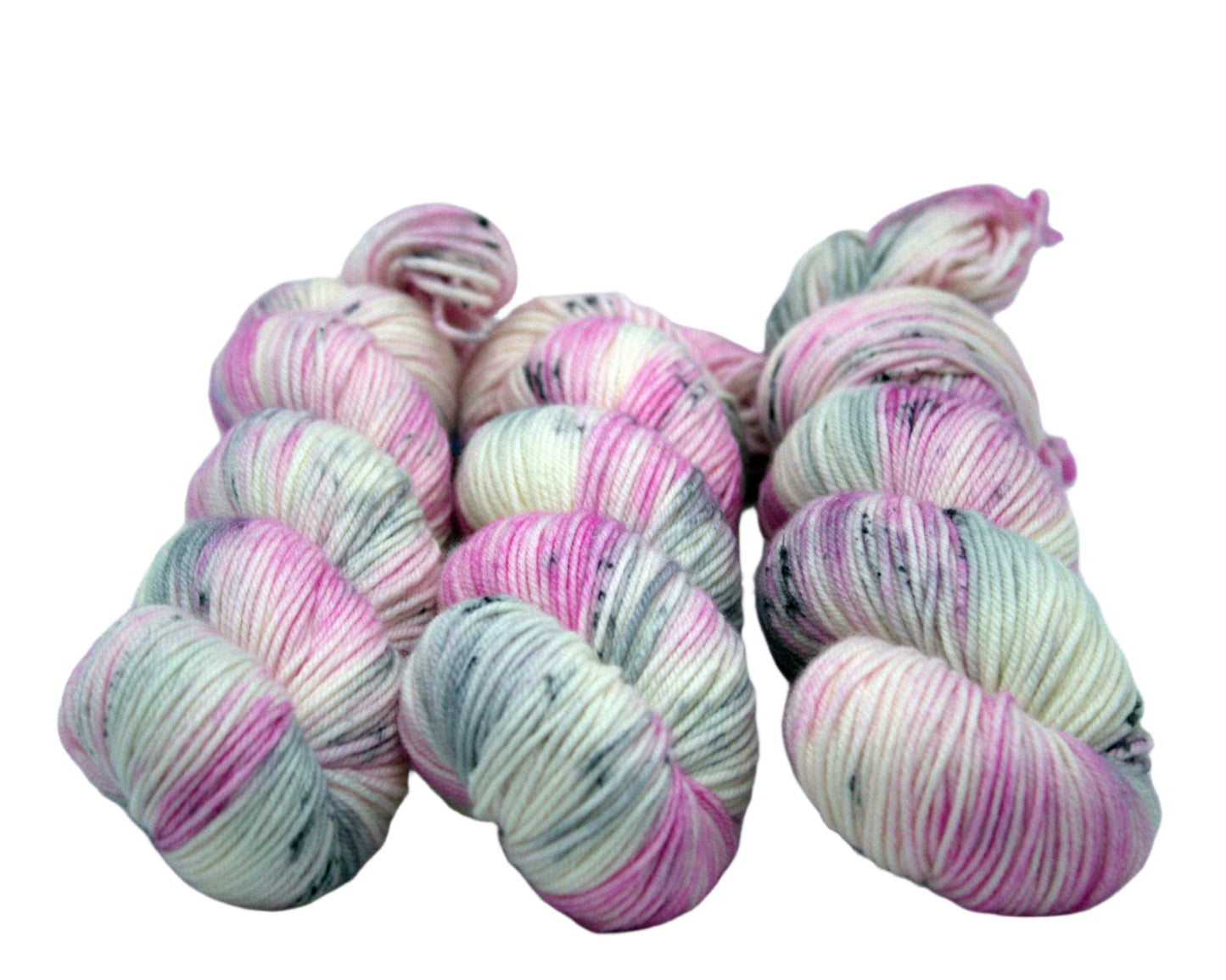 Three twisted skeins of pink, white and gray yarn with dark gray speckles on white background.