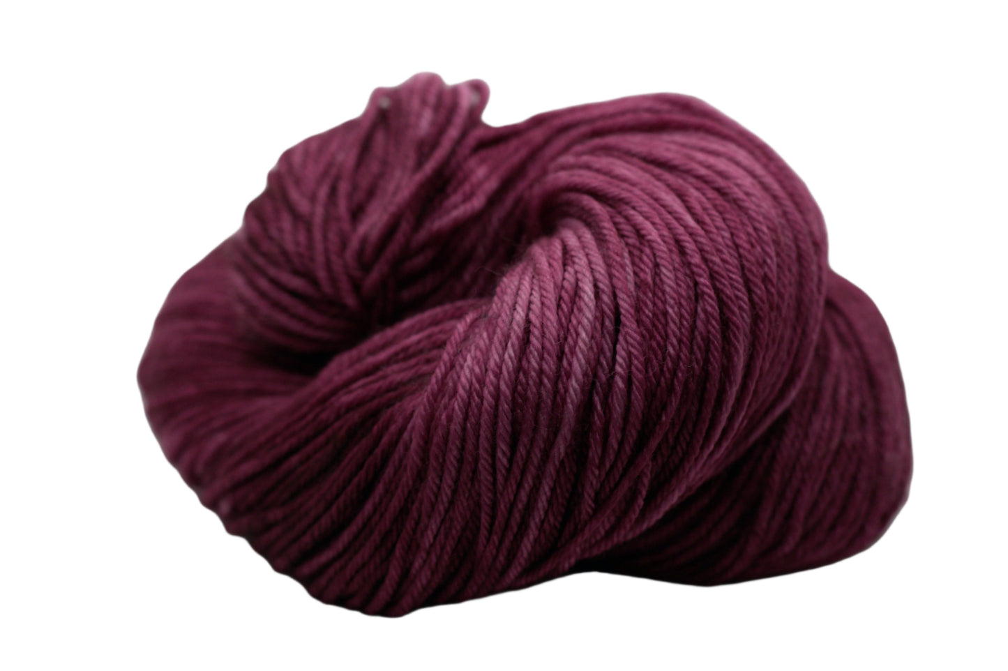 curled up skein of tonal red plum colored yarn on white background.