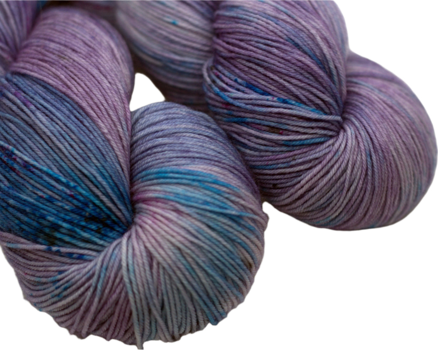 close up of two twisted skeins light purple yarn with turquoise, magenta and black speckles on white background.