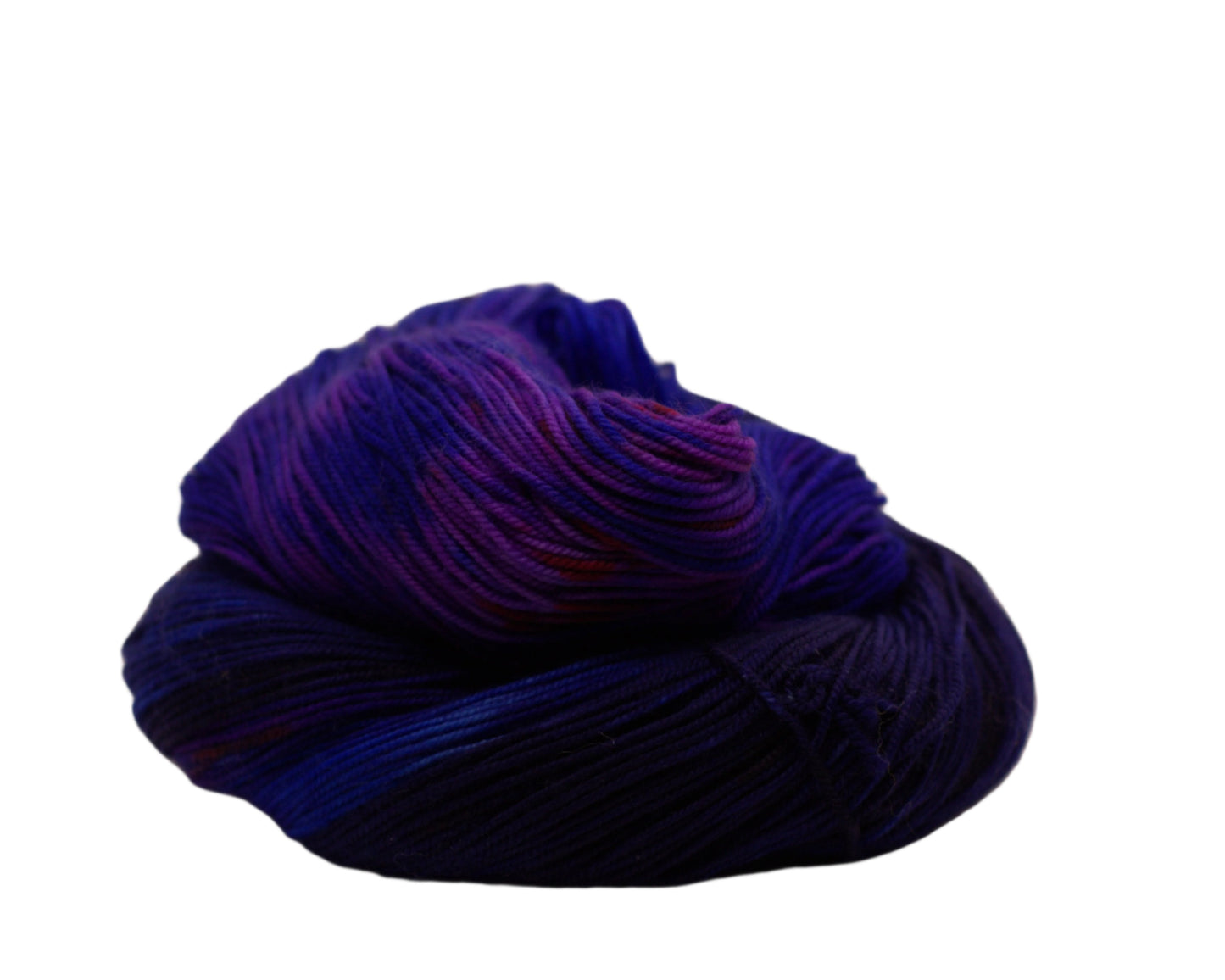 one curled skein of blue layered over red yarn on white background.