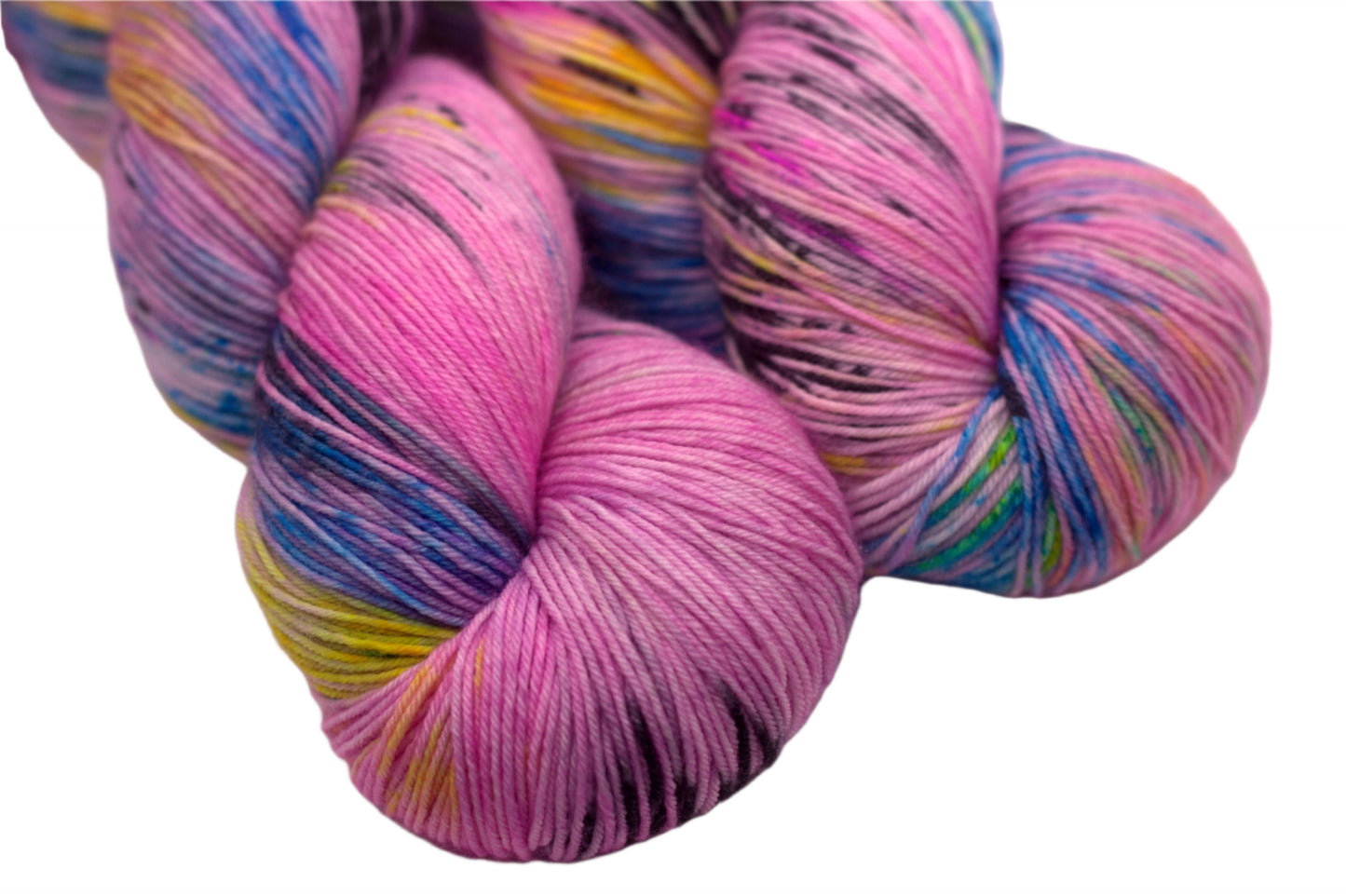 close up of two twisted skeins of pink yarn with turquoise, yellow and black speckles on white background.