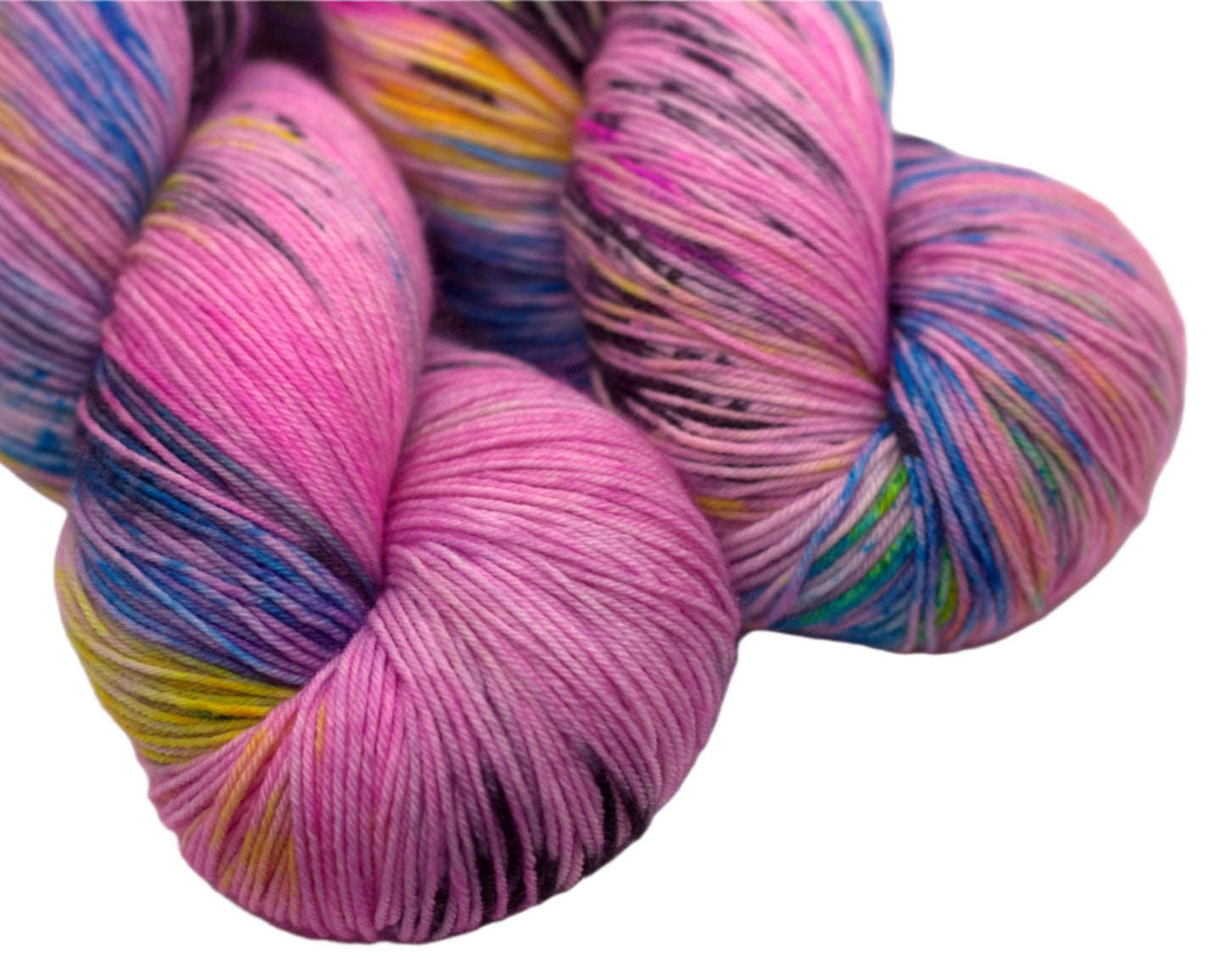 close up of two twisted skeins of pink yarn with turquoise, yellow and black speckles on white background.