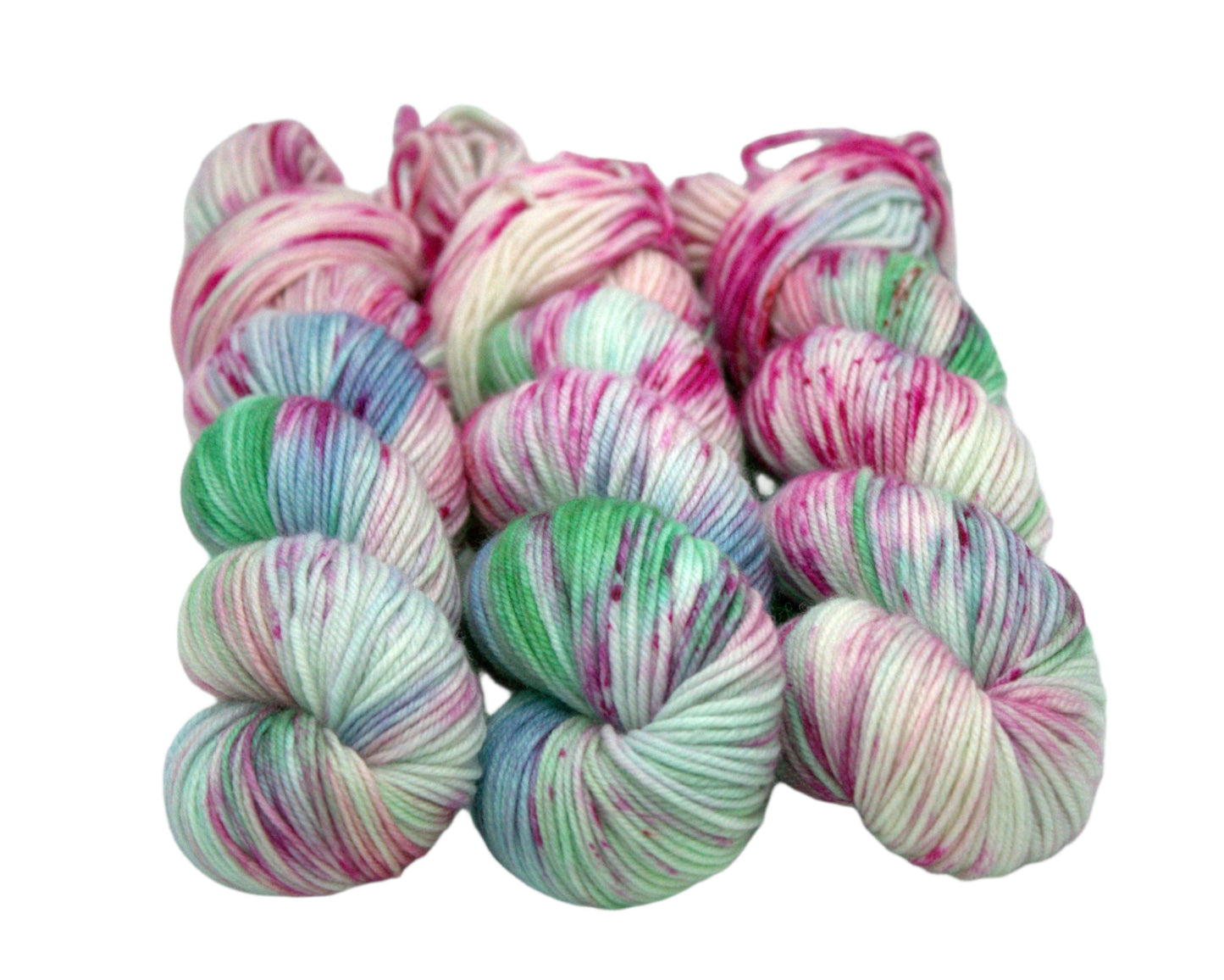 three twisted skeins of pink, blue and green speckled yarn on white background.