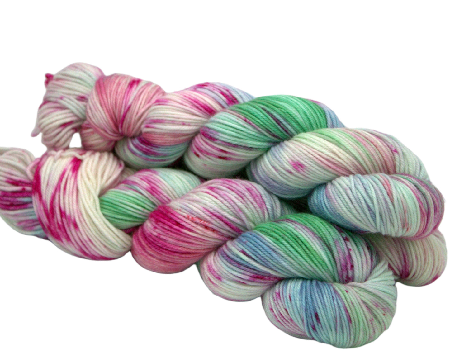 side view of three twisted skeins pink, blue and green speckled yarn on white background.