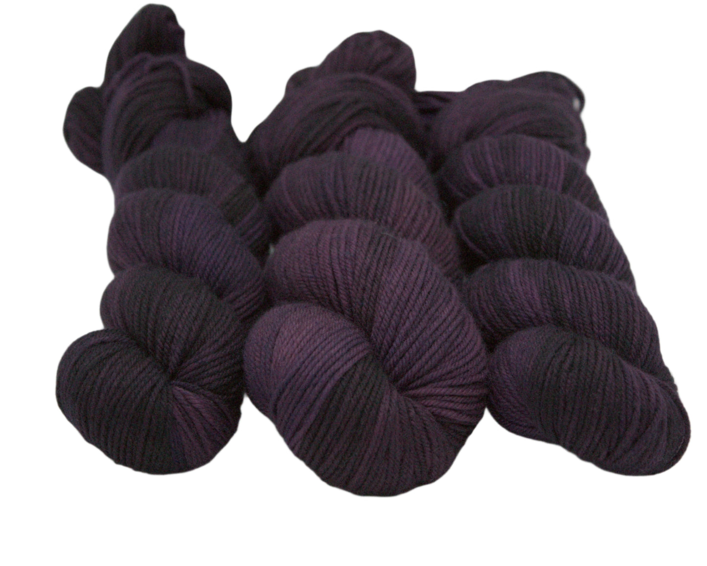 three twisted skeins tonal plum yarn on white background.