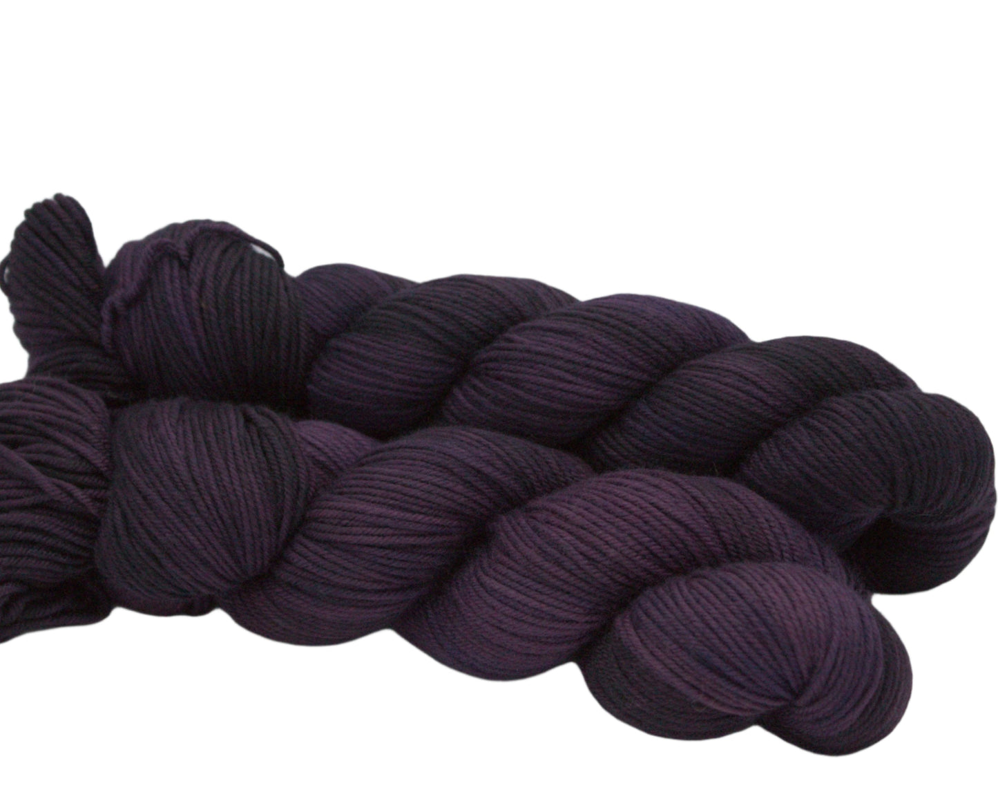 side view of two twisted skeins tonal plum yarn on white background.