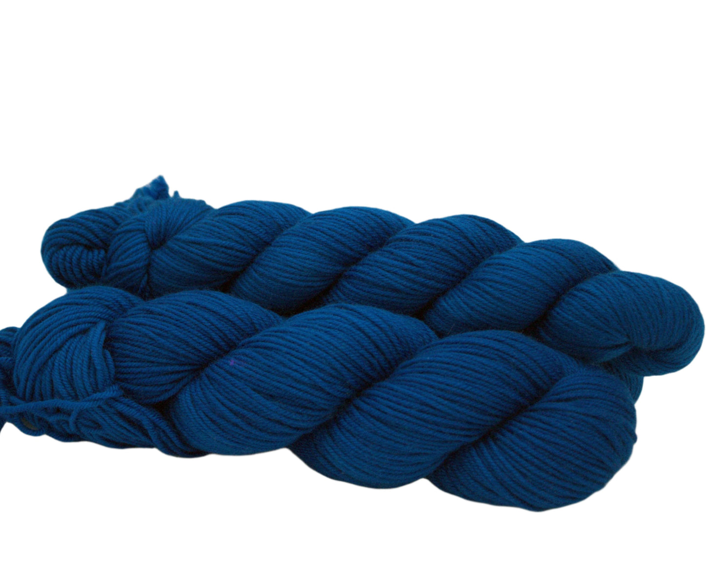side view of three twisted skeins peacock blue yarn on white background.