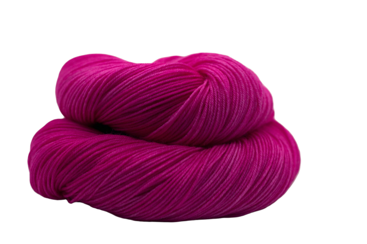 one curled up skein tonal bright pink yarn on white background.