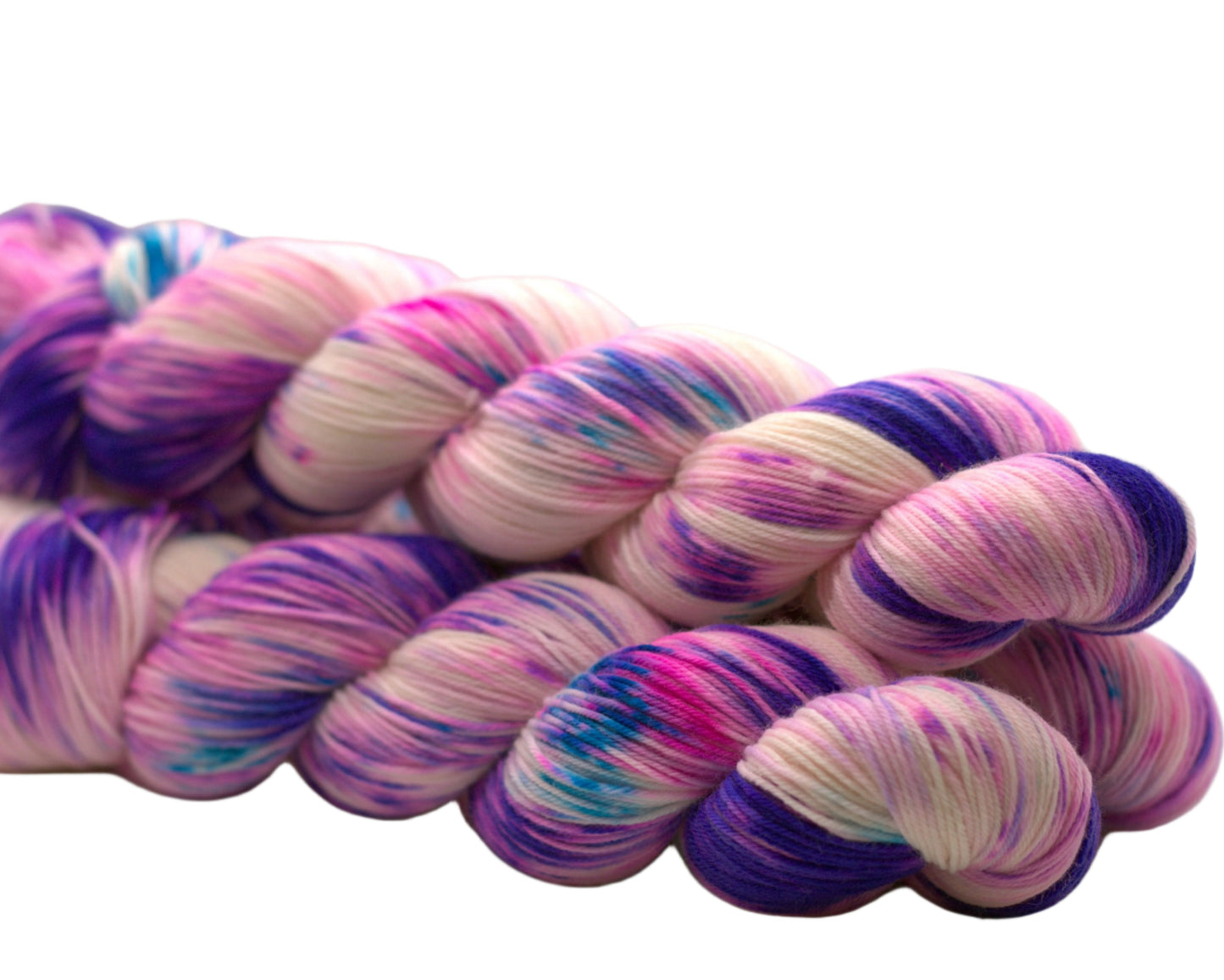 Side view of three twisted skeins of purple, pink, and aqua speckled yarn on a white background