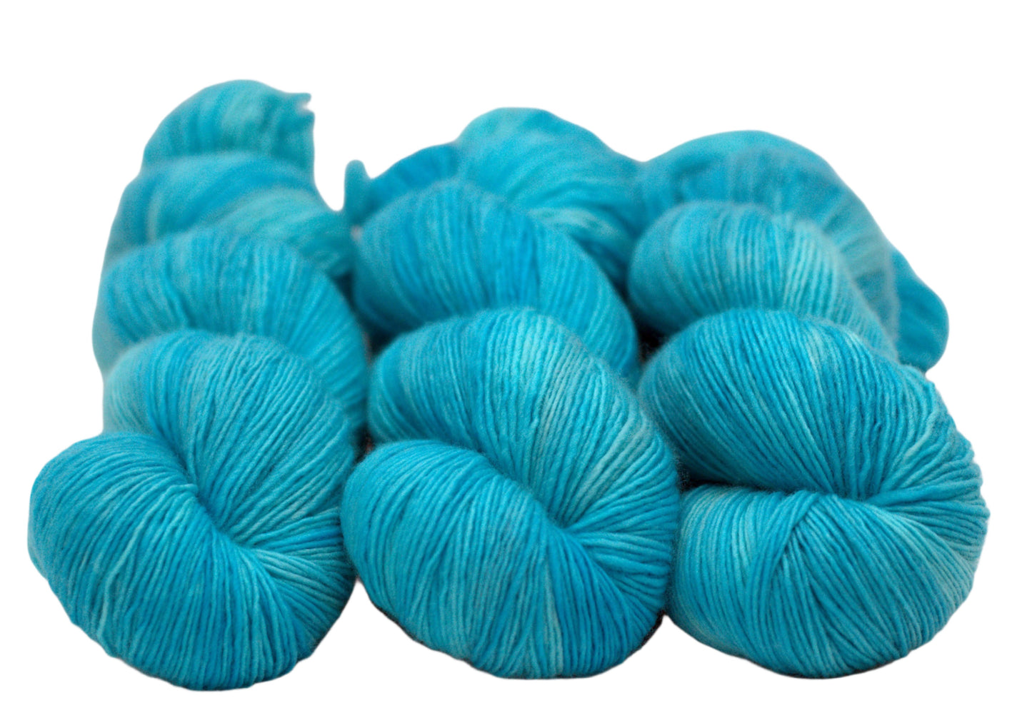 three twisted skeins tonal turquoise yarn on white background.