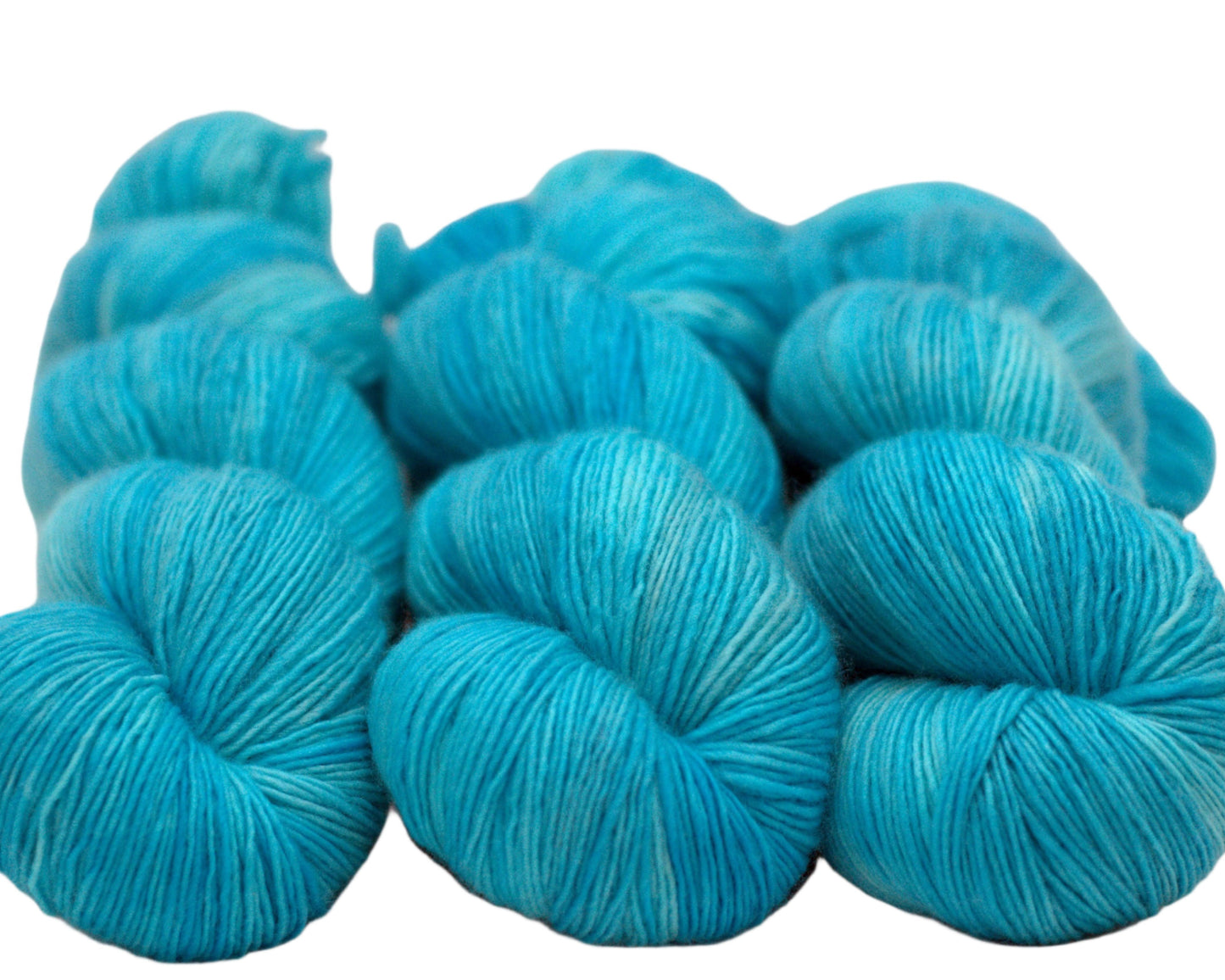 three twisted skeins tonal turquoise yarn on white background.