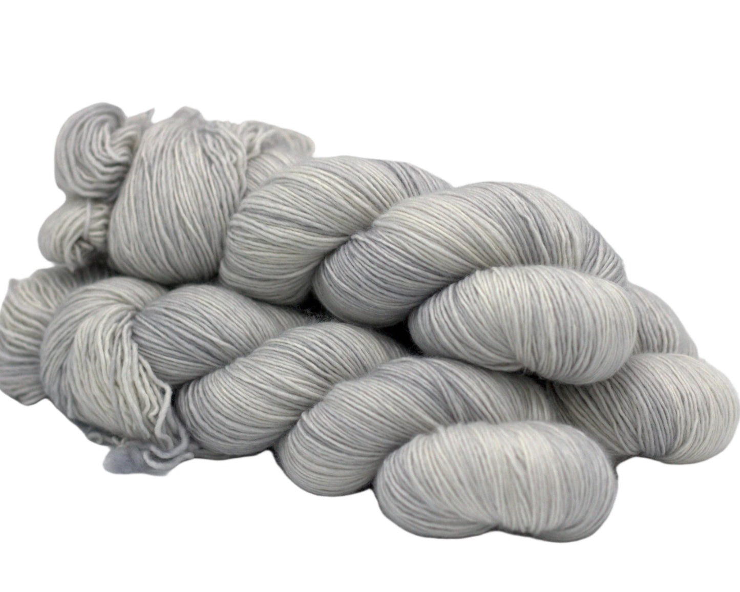 three twisted skeins tonal silver yarn on white background.