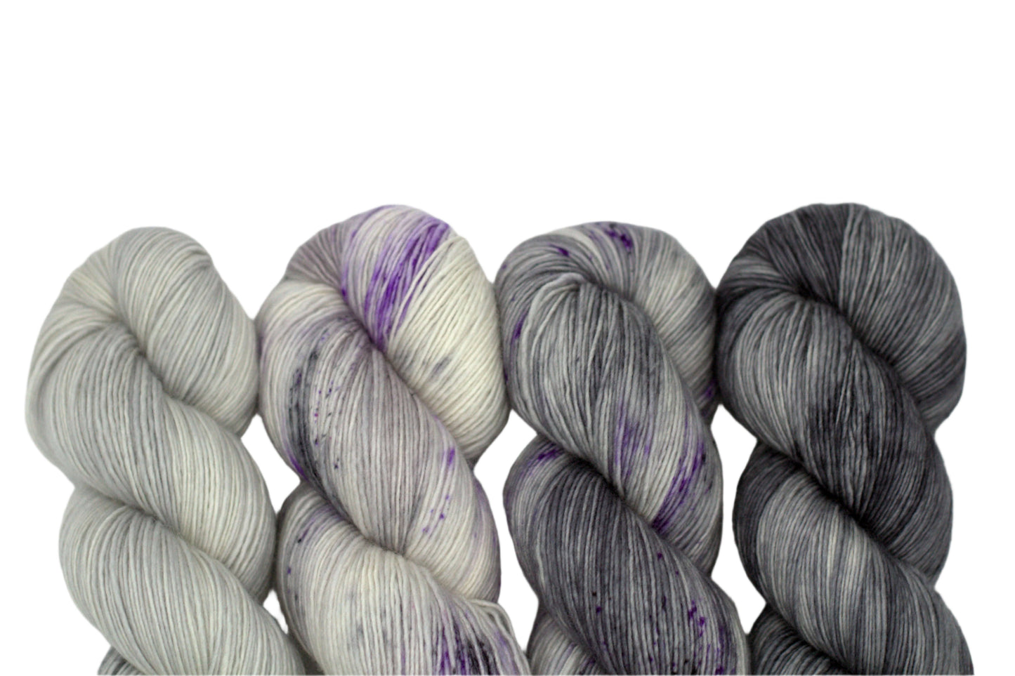 four twisted skeins of coordinating silver colored yarn on white background.