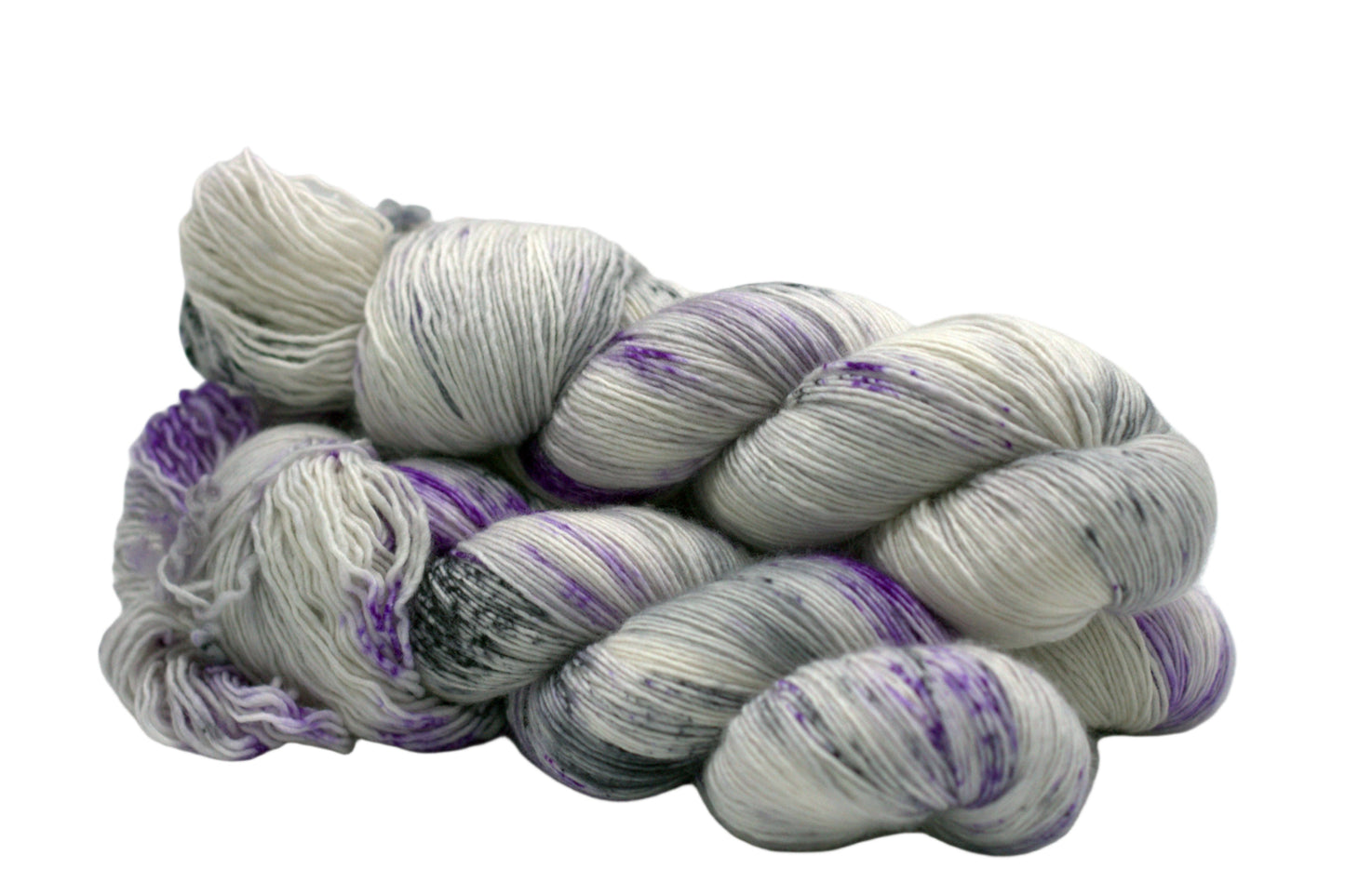 side view of three twisted skeins tonal silver yarn with purple and dark gray speckles on white background.