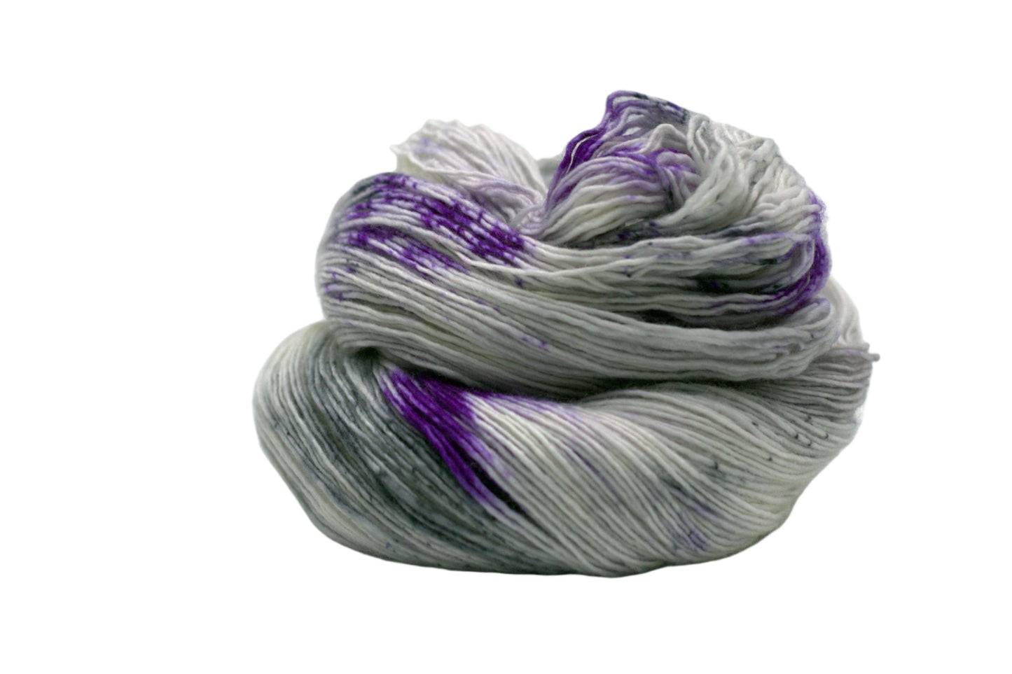 one skein curled up silver tonal yarn with purple and dark gray speckles on white background.