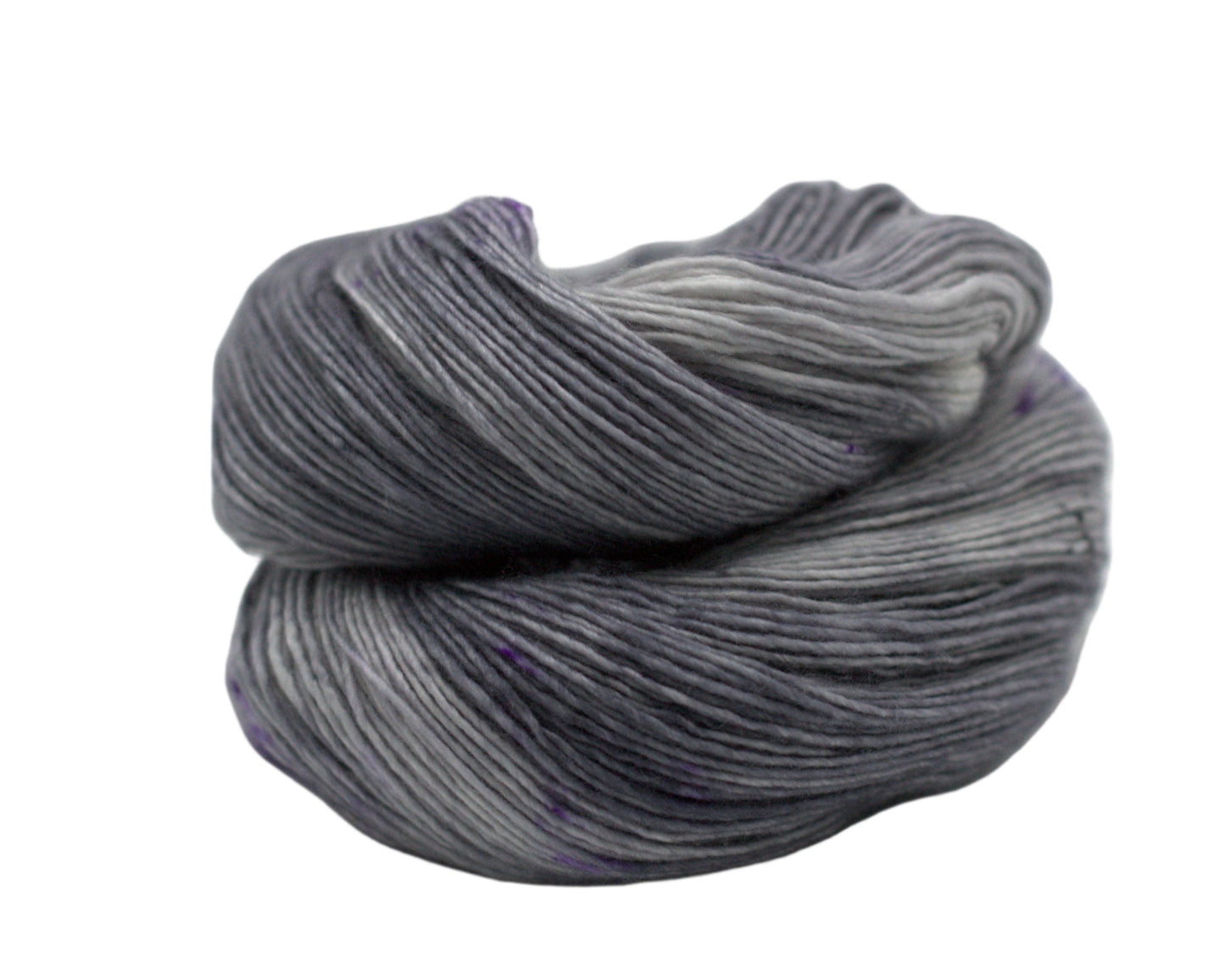 one curled up skein of tonal dark silver yarn with purple speckles on white background.