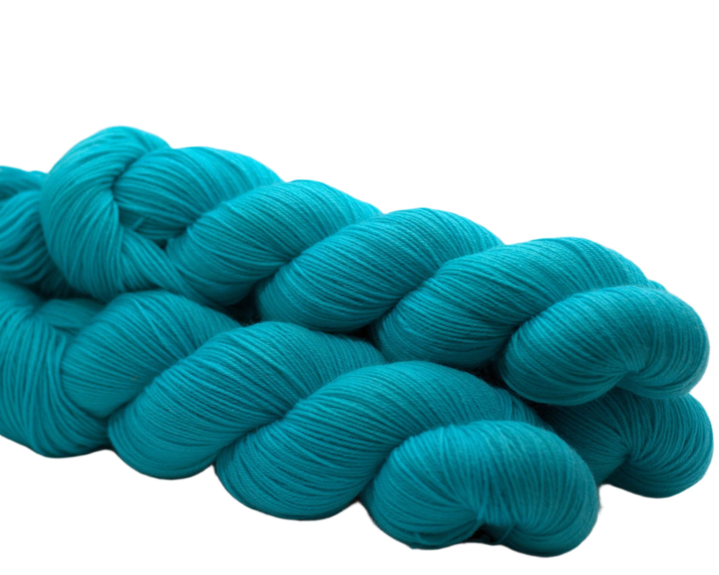 Side view of three twisted skeins of aqua colored yarn on a white background.