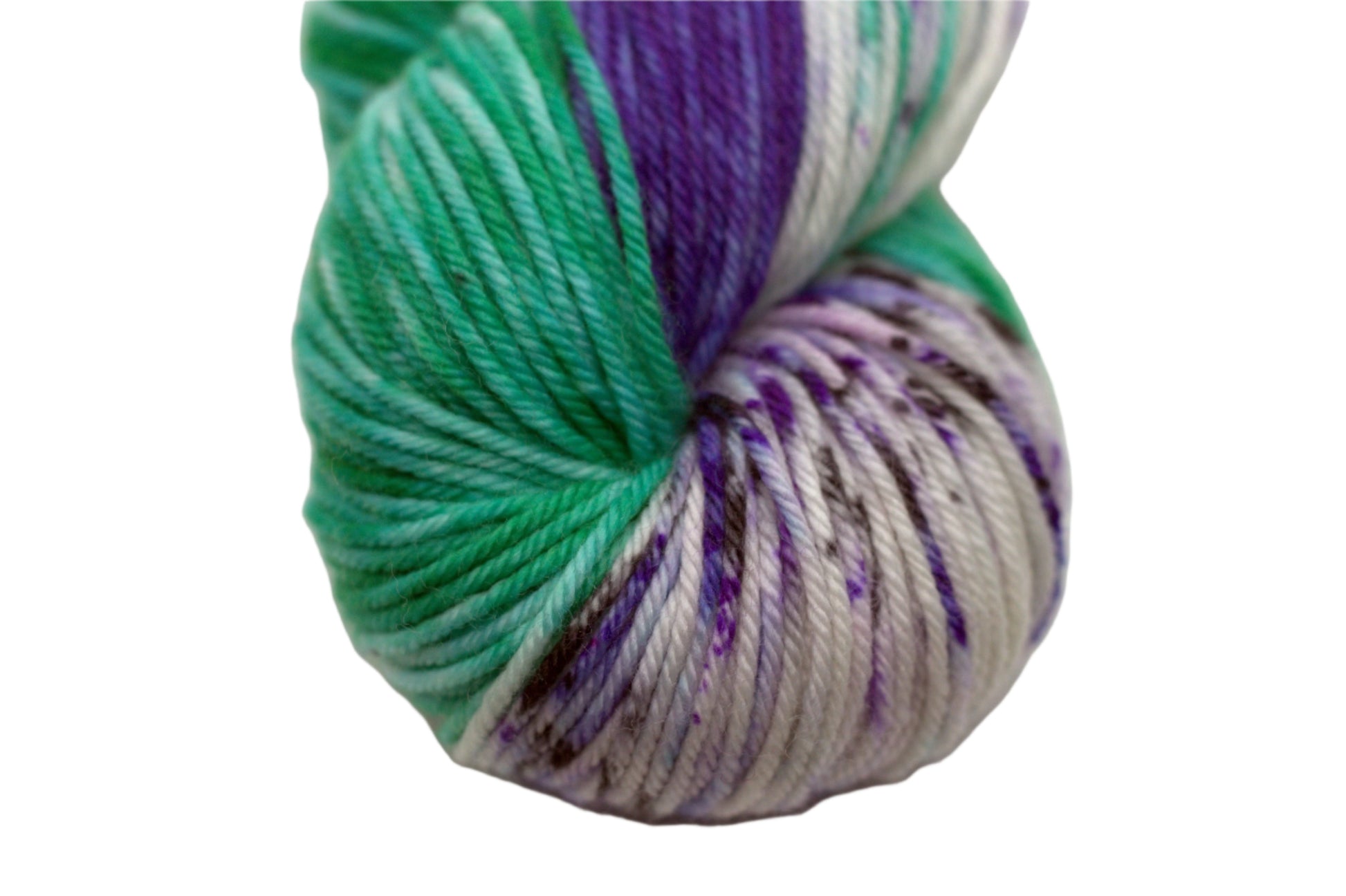 close up of one twisted skein variegated white, purple and green yarn with purple and black speckles on white background.