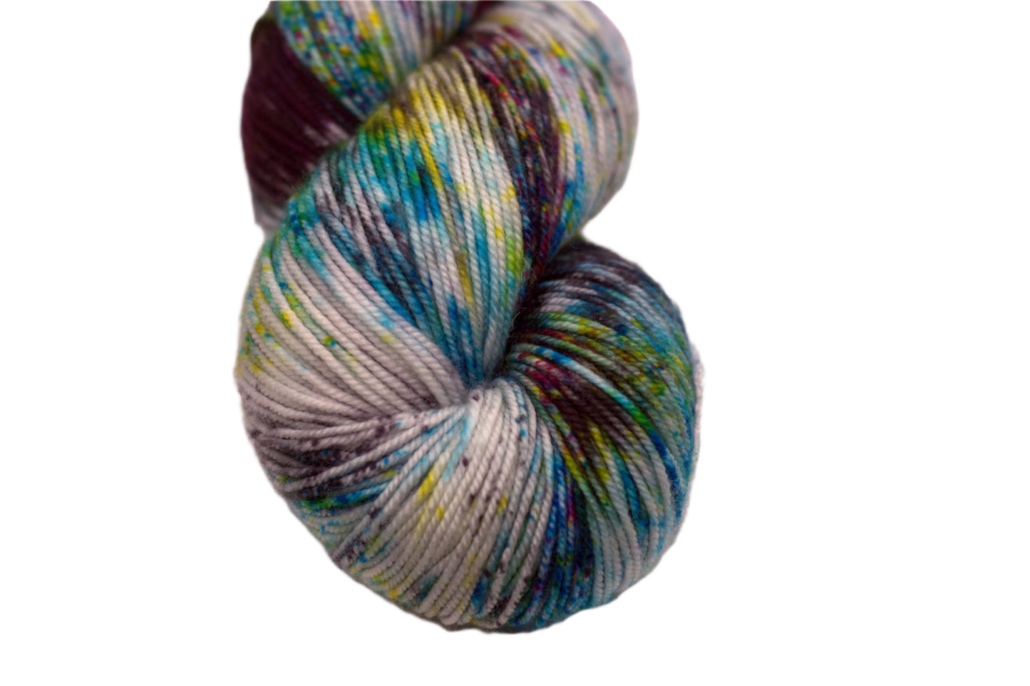 close up of one twisted skein multicolored speckled yarn on white background.