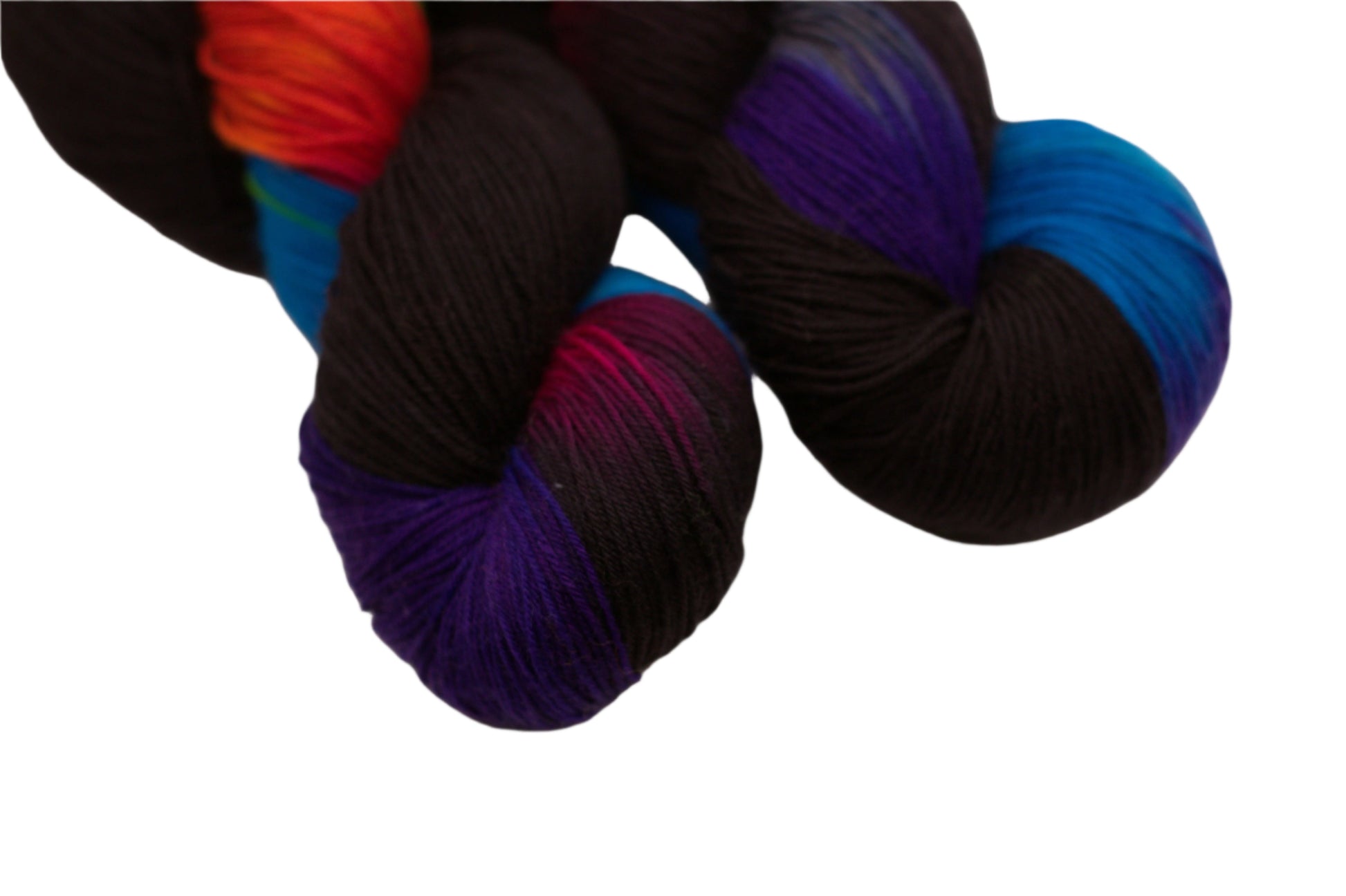 Top portion of two twisted skeins of black and rainbow colored yarn on a white background.