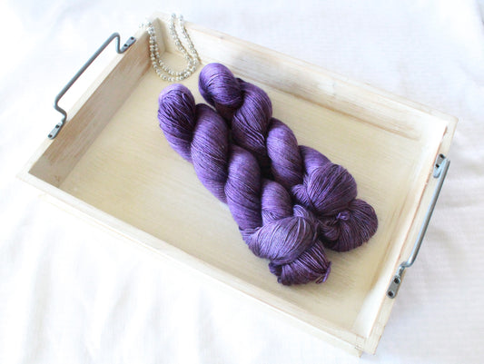 two twisted skeins of purple yarn with a nice sheen.