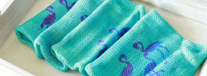 close up top view of sock blank that is turquoise in color with magenta flamingo stencils